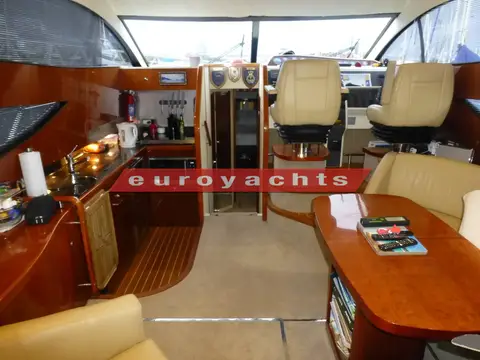 Fairline Phantom 46: saloon looking forward to galley at port and twin cream helm seats to starboard