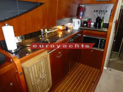 Fairline Phantom 46: galley with dark worktops, cherry-wood units, microwave and teak and holly floor