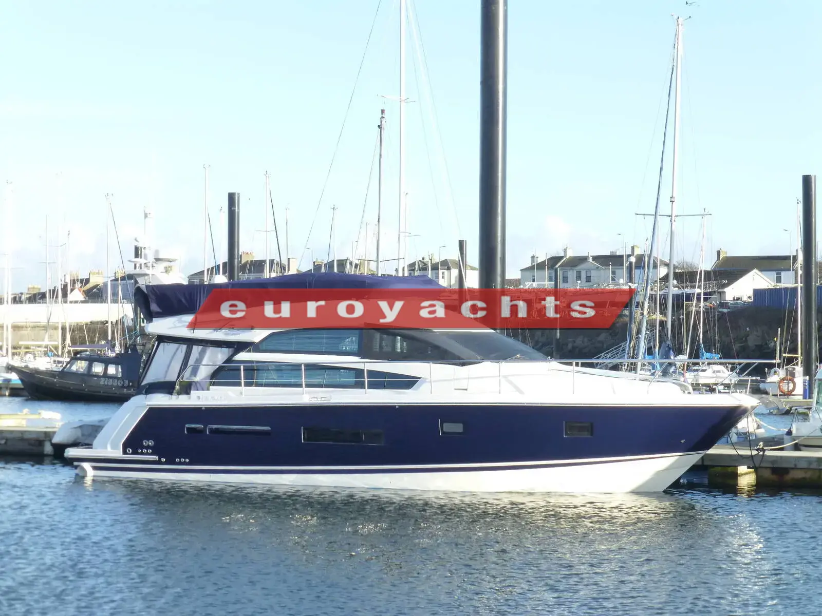 Fairline Squadron 42: navy and white hull with flybridge, moored in a marina on a sunny day