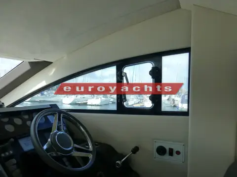 Fairline Squadron 42: side window beside the lower helm with an opening vent and marina view