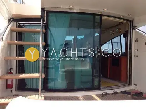 Fairline Squadron 58: aft cockpit with curved sliding glass saloon door and teak steps up to the flybridge