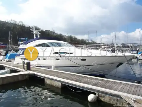 Fairline Squadron 58: starboard side of the white hull moored alongside a pontoon in a sheltered marina