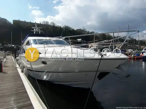 Fairline Squadron 58: bow quarter view showing stainless bow rails and flybridge with blue cover