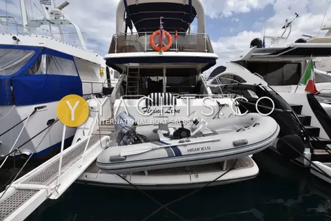 Fairline Squadron 62/65: stern view in a marina showing Highfield tender with Honda outboard on the bathing platform