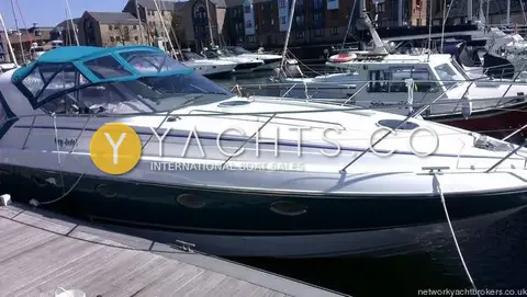 Fairline Targa 38: port side moored in marina with apartment buildings behind, green canopy fitted