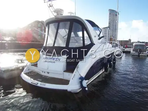 Fairline Targa 40: stern quarter view with canopy fitted, moored in a sunny marina beside apartment blocks