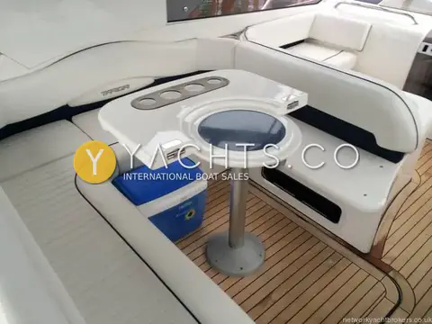 Fairline Targa 40: cockpit dining area with folding table, cupholders and cream seating on teak deck
