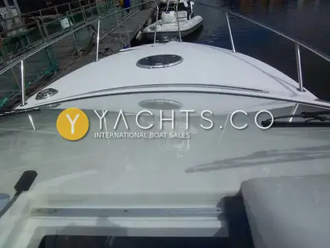 Falcon 27: foredeck seen through the windscreen, with hatch, rails and a marina pontoon ahead