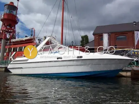 Falcon 27: white hull with blue antifouling, moored beside a red lightship in a dock