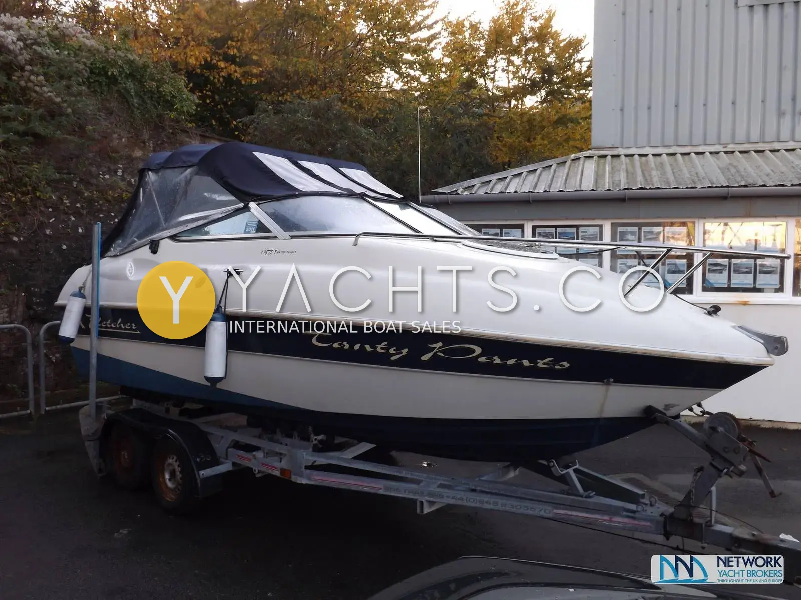 Fletcher 19GTS Sportcruiser: port bow view of the white and navy hull on a twin axle trailer with cockpit cover fitted