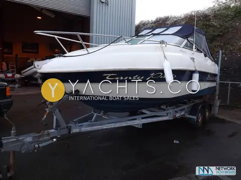 Fletcher 19GTS Sportcruiser: starboard bow view on the road trailer outside a boatyard workshop, bow rail visible