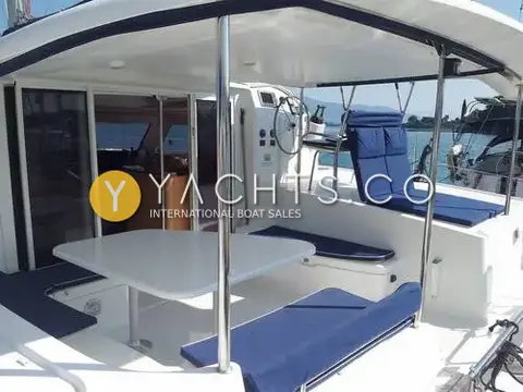 Fountaine Pajot Orana 44: cockpit with white table, blue cushions and sliding doors open to the saloon