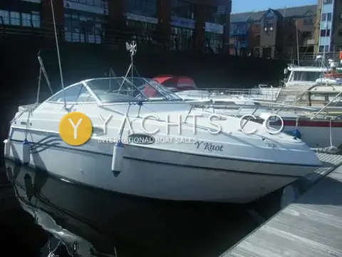 Four Winns 238 Vista: white hull with dark stripe graphics moored at a Swansea marina pontoon beside apartments