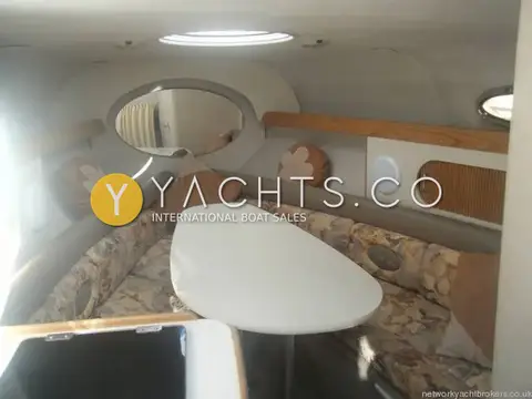 Four Winns 238 Vista: forward cabin seen from the entrance, showing deck hatch, porthole and floral upholstery