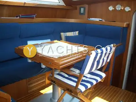 Franchini 45L: saloon corner with blue upholstered seating, teak table and striped folding chair