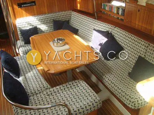 Gib Sea 43 Reduced: saloon dinette with patterned upholstery, navy cushions and varnished wooden table