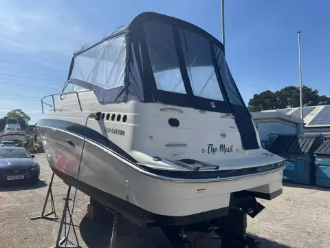 Glastron GT 249: stern quarter ashore showing transom name, camper cover and sterndrive leg