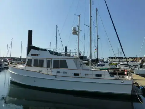 Grand Banks 42: port side view showing walkaround deck, flybridge and mast with radome, berthed in marina