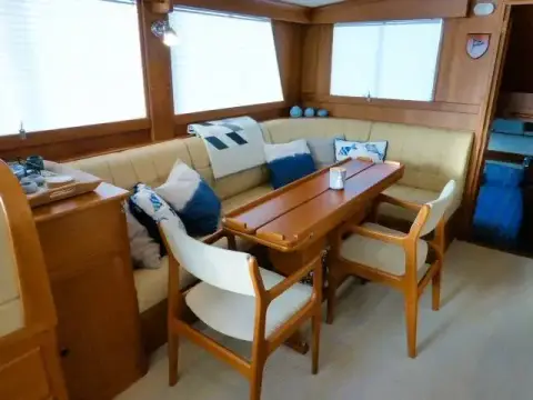Grand Banks 42: saloon with L-shaped settee, varnished dining table and two wooden chairs