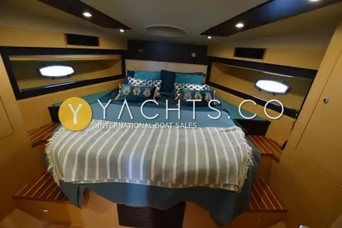 Gulf Craft Oryx 46 Fly: master cabin double bed with teal cushions, striped throw and oval hull portlights