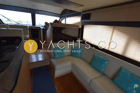 Gulf Craft Oryx 46 Fly: saloon with cream L-shaped sofa, turquoise cushions, wood floor and blinds over the windows