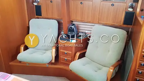 Hallberg-Rassy 43: two upholstered armchairs in mahogany saloon with coffee machine on small cabinet between