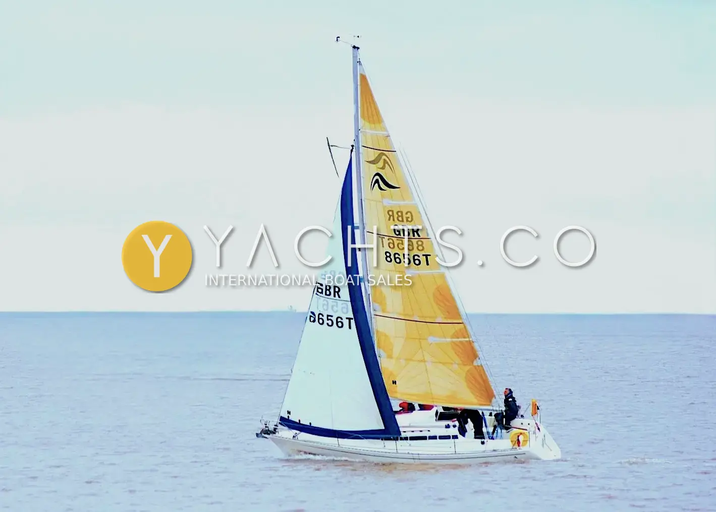 Hanse 301: under sail on open water with yellow patterned mainsail and white jib, sail number GBR 8656T