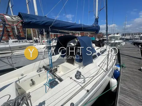 Hanse 301: cockpit and companionway under blue sprayhood, with cockpit winch and mainsheet traveller