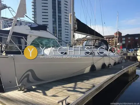 Hanse 315: silver-grey hull with swirl graphic, moored on a pontoon among Cardiff waterfront buildings