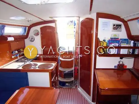 Hanse 341 Yacht For Sale: view aft past galley to companionway steps, aft cabin door and chart table with bookshelf