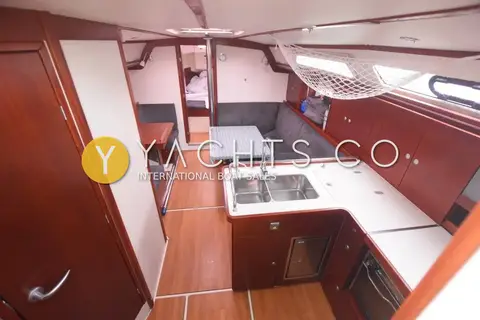Hanse 370: saloon looking forward past the galley, with wood joinery and wood-effect floor