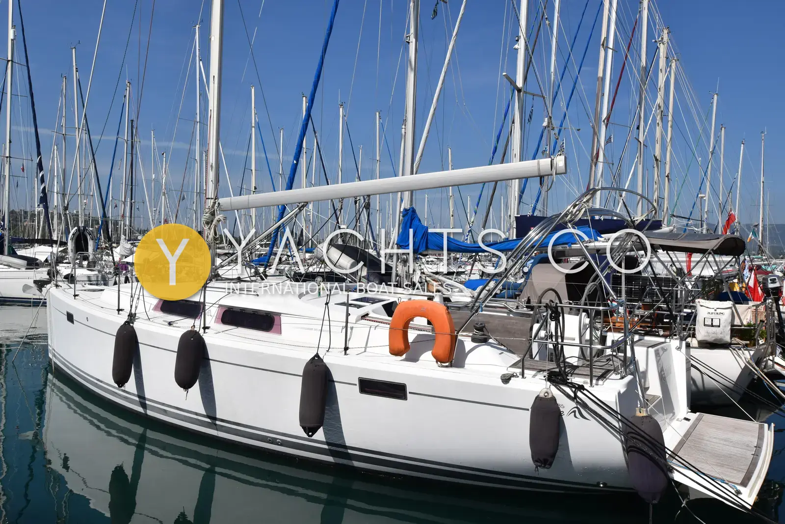 Hanse 385: starboard side of the white hull moored stern-to in a marina, fenders out, with teak bathing platform
