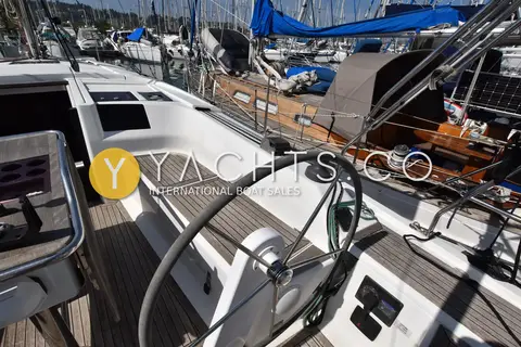 Hanse 385: starboard helm wheel beside teak cockpit seat, with engine controls set into the coaming