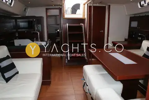 Hanse 545: saloon looking aft to companionway steps, cream leather seating and dark wood table