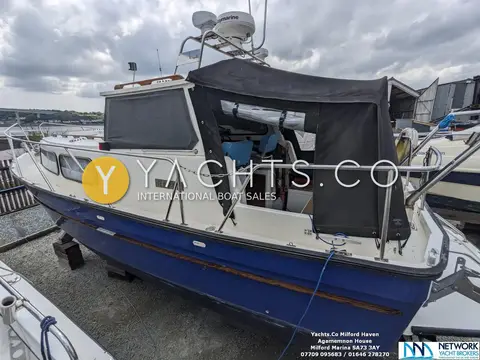 Hardy Marine 25: port side ashore with cockpit canopy door open showing blue helm seats inside