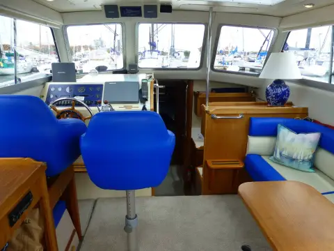 Hardy Marine 32 Commander: wheelhouse looking forward with blue helm seats, starboard settee and three-section windscreen