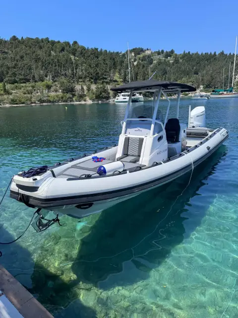 Highfield 900 Sport: port side afloat in a sheltered bay, wooded shore and moored yachts behind