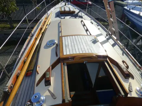 Holman Twister 28: cream-painted coachroof with varnished teak hatch and toerails, looking forward from the cockpit