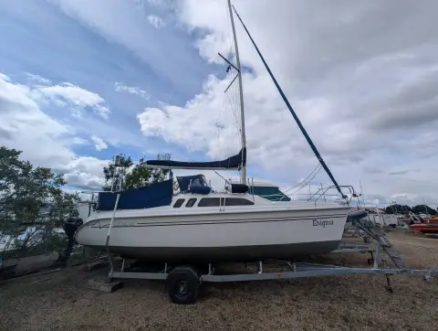 Hunter Legend 240: boat ashore on her road trailer with mast stepped, under cloudy sky