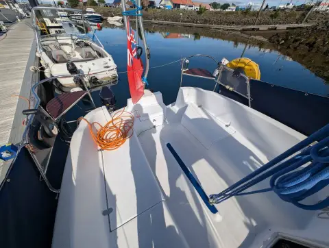 Hunter Legend 240: cockpit looking aft towards the stern rail, ensign and coiled orange shore power cable