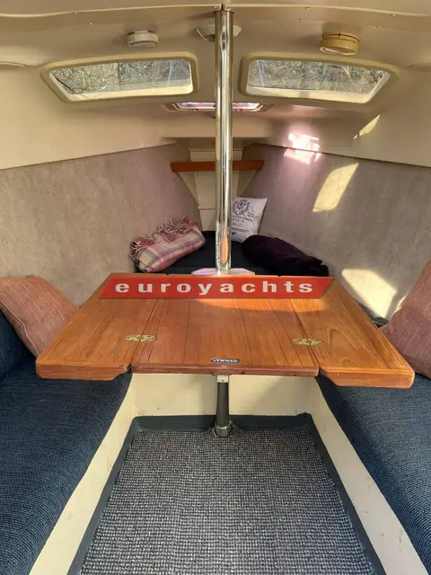 Hunter Legend 25 Trailer Sailer: saloon with teak folding table opened between blue settees, hatches overhead