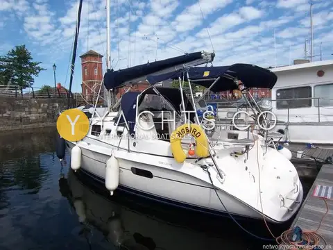 Hunter Legend 326: starboard side of the white hull moored in a dock with brick buildings behind