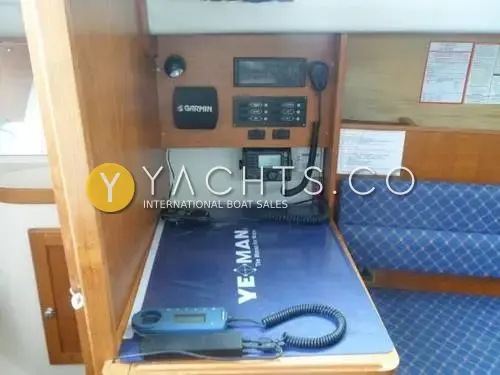 Hunter Ranger 265: navigation station with Garmin GPS, VHF radio, switch panel and chart table beside blue saloon seating