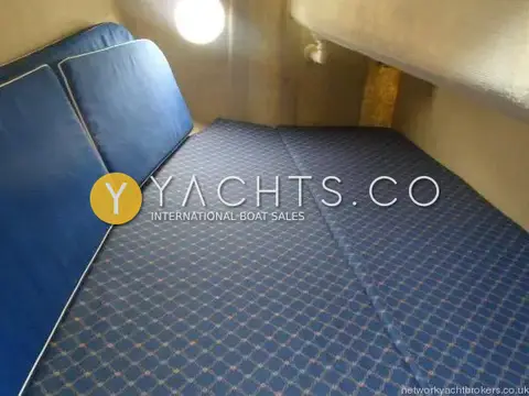 Hunter Ranger 265: aft cabin double berth in blue patterned upholstery with backrest cushions and cabin light