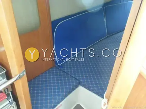 Hunter Ranger 265: aft cabin seen through doorway, showing blue upholstered berth and separate seat