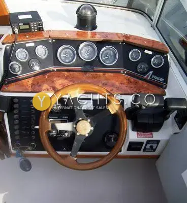 Invader 265: helm with wooden wheel, burr wood dash panel, row of gauges and twin throttles