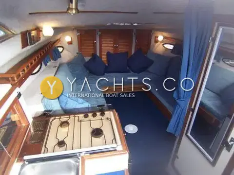 Invader 265: saloon from the companionway, gas hob in foreground and blue U-shaped dinette forward