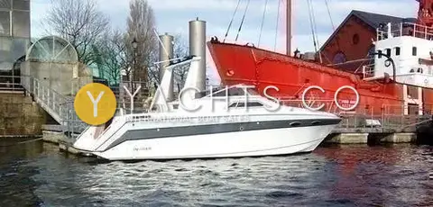 Invader 265: hull from the side, moored beside a red lightship in a dock