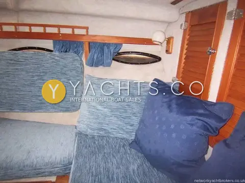 Invader 265: corner of the forward dinette with blue cushions and louvred locker doors