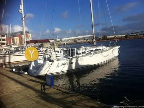 J Boats J/109: port side view alongside a marina pontoon in evening sun with buildings behind
